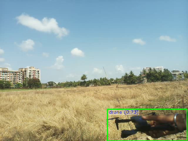 A hand-held drone in a dry grass field, marked by a green drone box